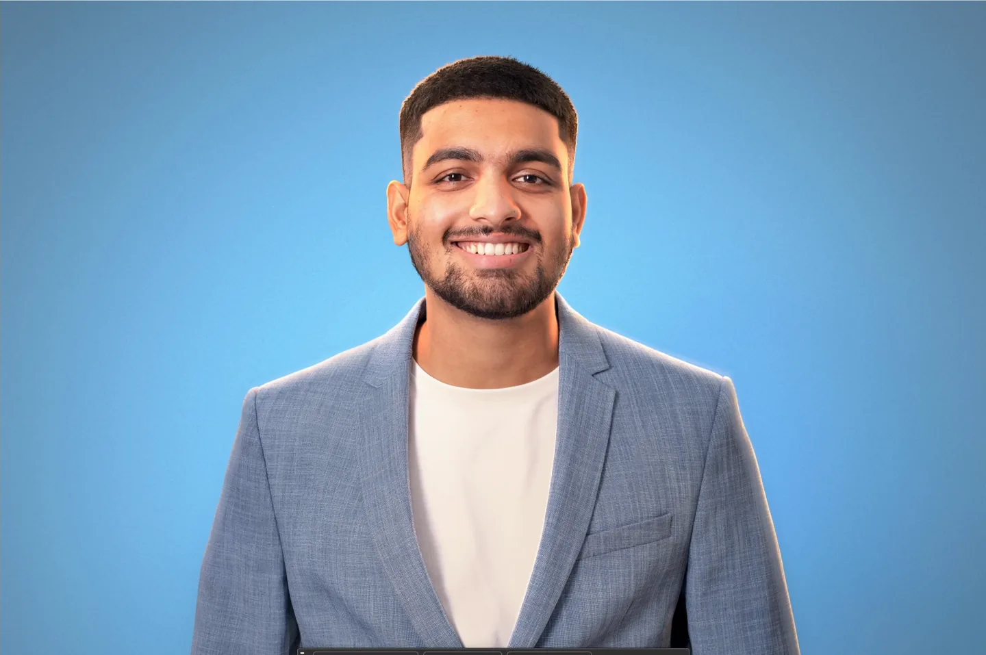 The final relit portrait: a man in a blue blazer with warm rim light against a blue backdrop