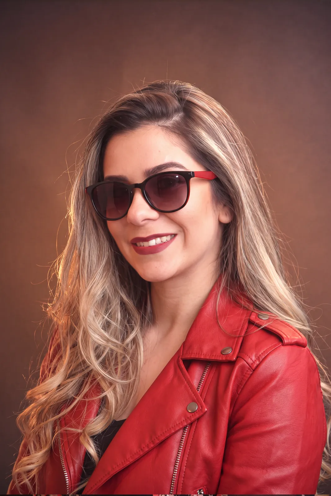 The same woman edited by Nano Banana 2.1 into a red leather jacket and sunglasses, her head turned slightly